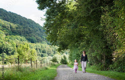 Mother and daughter walking on rural road, Porta Westfalica, North Rhine Westphalia, Germany photo