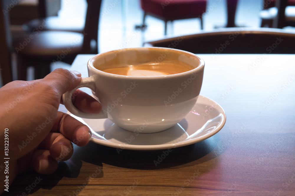 Fototapeta premium Hot coffee in white cup in hand