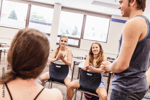 Teenage boy applauded by high school students in dance class photo