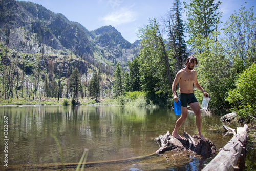 Man carrying bottles of water from stream, Enchantments, Alpine Lakes Wilderness, Washington, USA