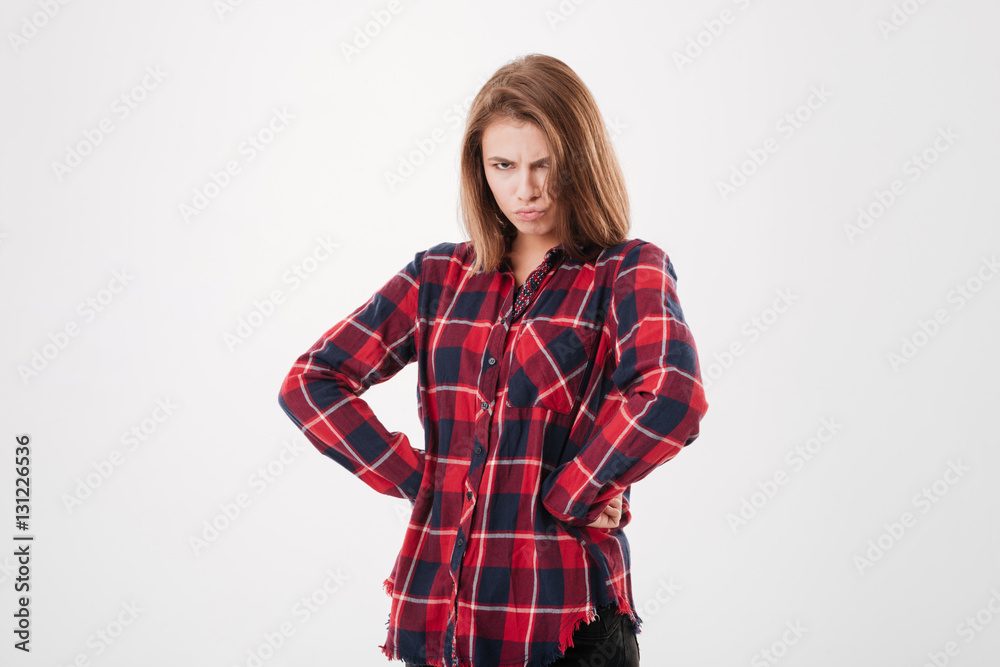 Upset woman in plaid shirt standing with hands oh hips Upset woman in plaid shirt standing with hands oh hips