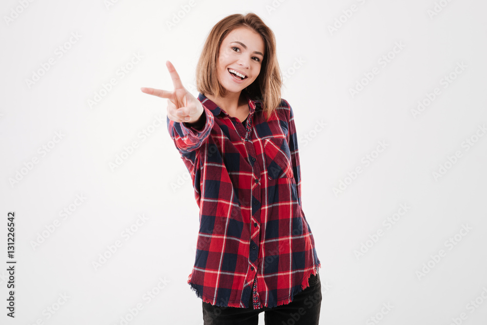 Smiling happy woman showing peace sign and looking at camera Smiling happy woman showing peace sign and looking at camera