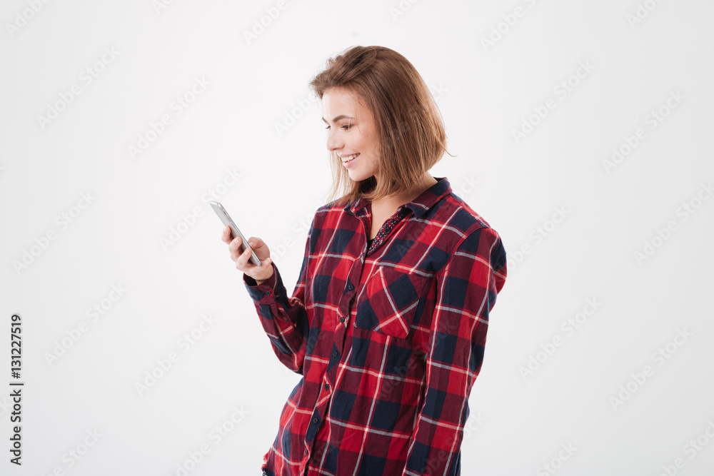Happy smiling woman in plaid shirt using smartphone Happy smiling woman in plaid shirt using smartphone