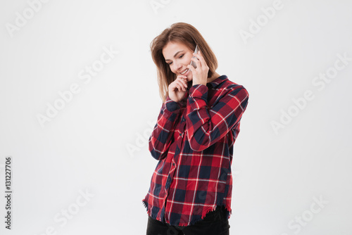 Pretty smiling girl standing and talking on mobile phone