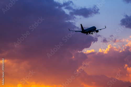 Passenger airplane flying in the sky at sunset