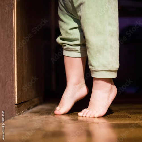 Baby bare feet in front of closed door