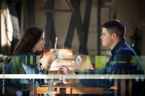 Two young people in cafe enjoying the time spending with each other