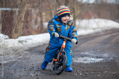 Fototapeta Naklejka Na Ścianę i Meble -  Child in ride balance bike (run bike) at winter