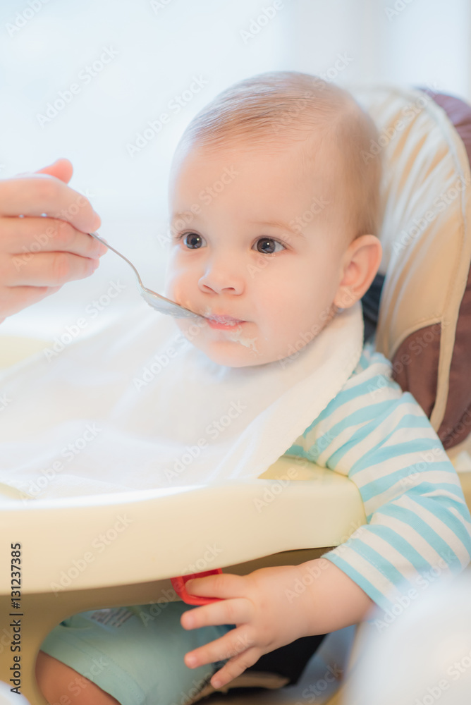 grandmother gives baby food from a spoon grandmother gives baby food from a spoon