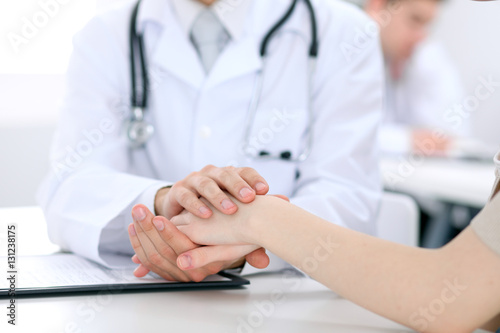 Hand of doctor reassuring her female patient