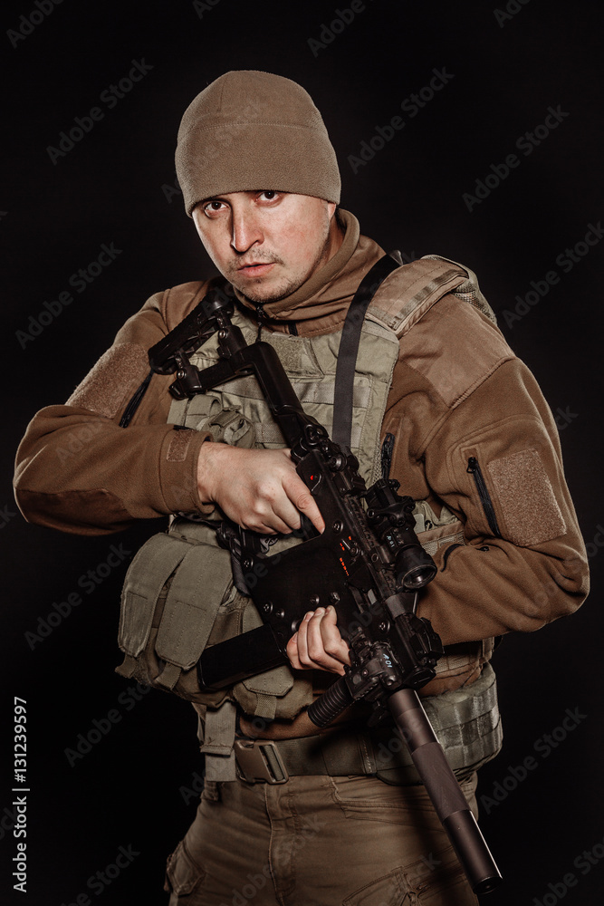 Portrait soldier or private military contractor holding rifle.