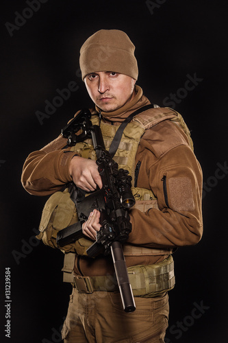 Portrait soldier or private military contractor holding rifle.