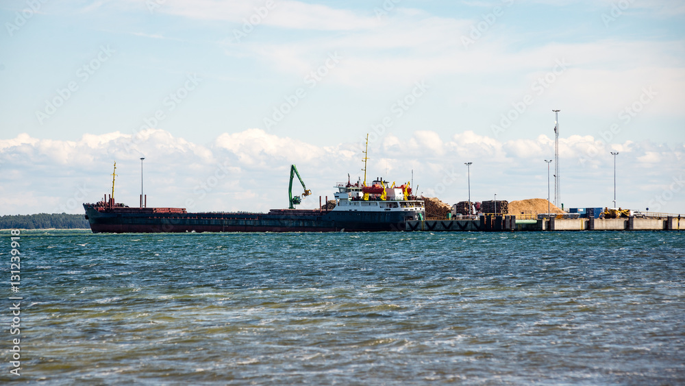 Fototapeta premium cargo ship is leaving port sailing away