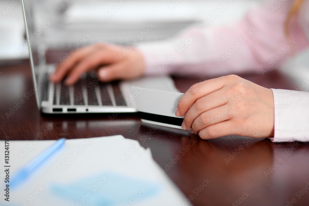 Close up of business woman hands using credit card and laptop computer Close up of business woman hands using credit card and laptop computer