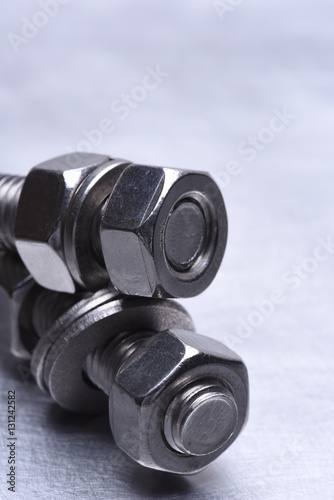 Steel Nuts and Bolts on Metal Background