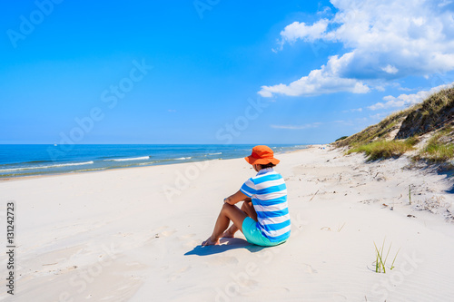 Young woman sitting on sand on Lubiatowo beach, Baltic Sea, Poland
