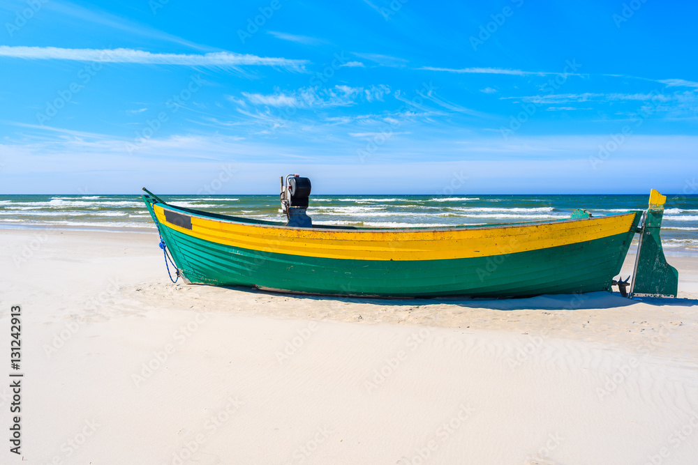 Colorful fishing boat on sandy Debki beach, Baltic Sea, Poland