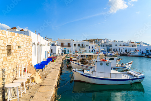 Traditional Greek fishing boats mooring in Naoussa port at sunset time on Paros island, Greece