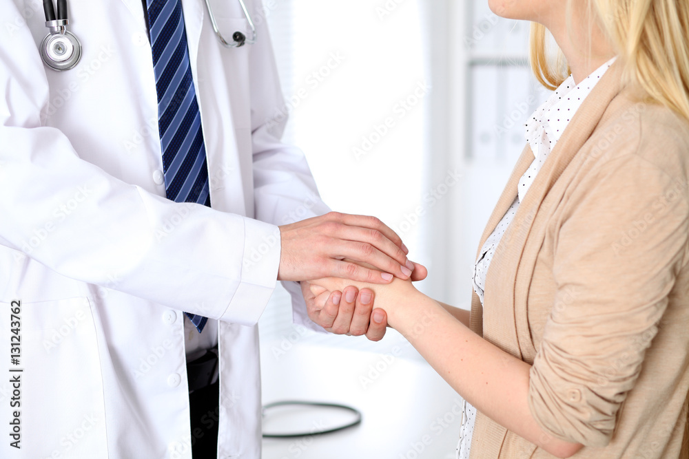 Obraz premium Hand of doctor reassuring her female patient. Medical ethics and trust concept