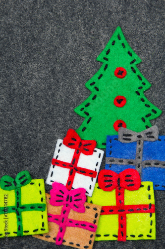 Christmas tree and colorful gifts on grey background. Felt Christmas ornaments with copy space