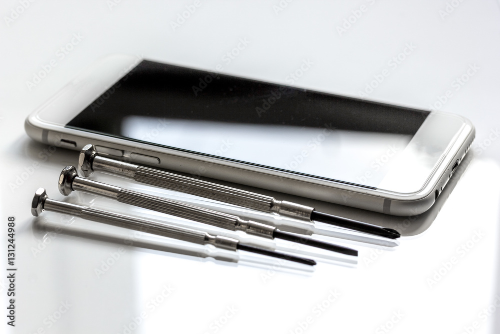 concept repair digital gadgets with screwdriver on white background concept repair digital gadgets with screwdriver on white background