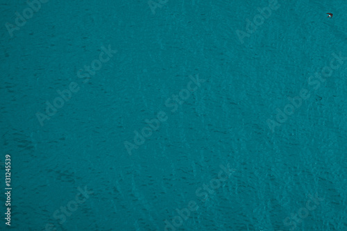 Blue water texture with a bird in the top right corner