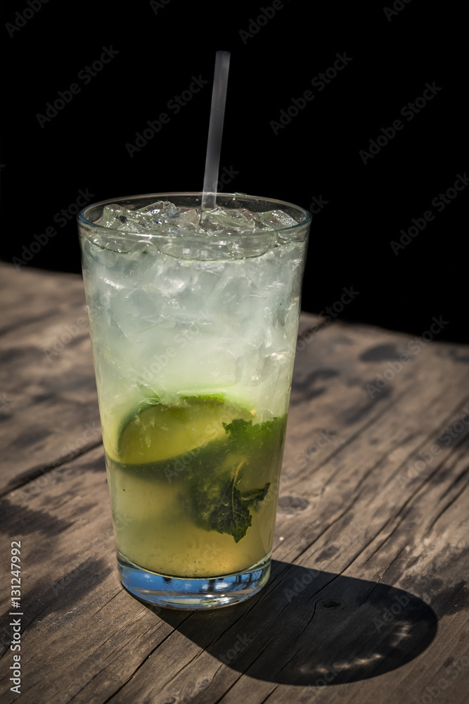 Summer drink with lime on a wooden table Summer drink with lime on a wooden table