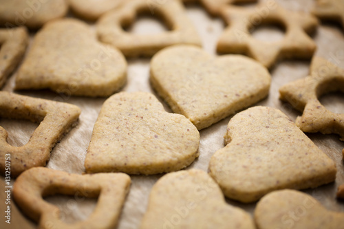Homemade baked heart and star shaped biscuits on the baking pape