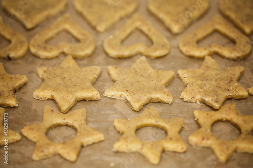 Raw homemade baked heart and star shaped biscuits on the baking