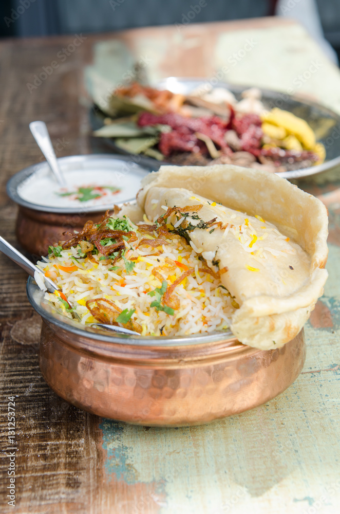 Authentic chicken biryani served with naan bread, fragrant pilau rice