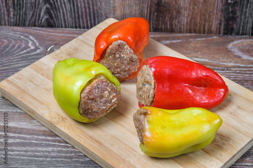 Raw Colored bell peppers stuffed with meat on a cutting Board photo
