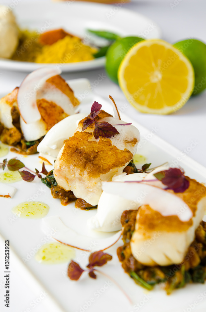 Fresh pan seared, crispy golden cod fish fillet, served on a bed of curried cauliflower, spinach and potato. A beautiful seafood dish.