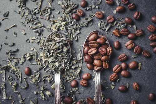 Cuadro en lienzo Green tea leaves and coffee seeds on metal spoons.