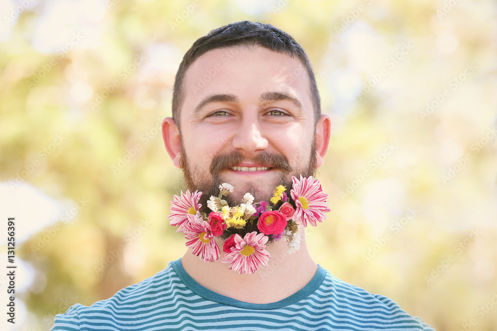 Handsome man with beard of flowers on light background Handsome man with beard of flowers on light background