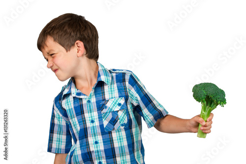 Young Boy Turning his Head away from a Broccoli Bunch