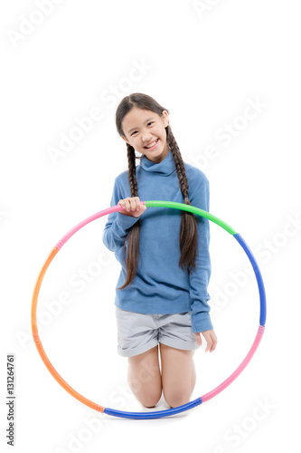 Portrait of happy little Asian child girl playing hulahoop on isolated white background