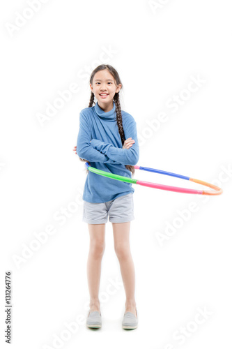 Portrait of happy little Asian child girl playing hulahoop on isolated white background