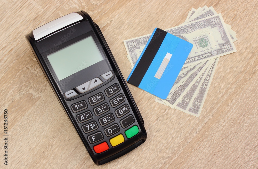 Payment terminal with credit card and money on desk, finance concept Payment terminal with credit card and money on desk, finance concept