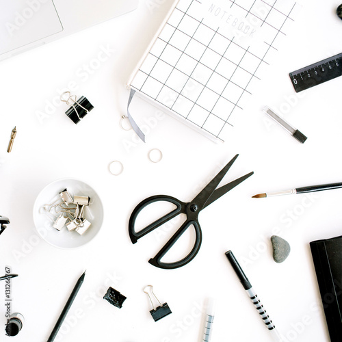 Flat lay, top view office table desk. Workspace with notebook, laptop, scissors, glasses, pen on white background.