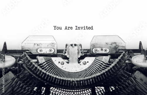 Vintage typewriter on white background with text you are invited