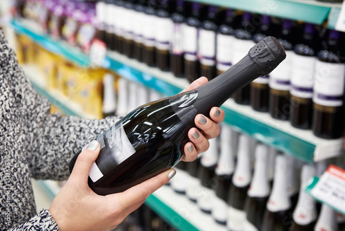 Woman with bottle of champagne in store