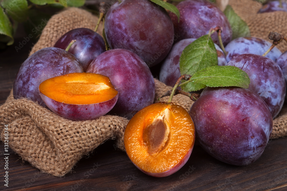 Fototapeta premium plums on the wooden background with sackcloth