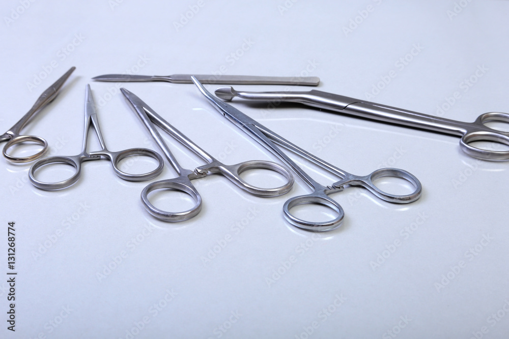 surgical instruments and tools including scalpels, forceps tweezers arranged on a table for surgery surgical instruments and tools including scalpels, forceps tweezers arranged on a table for surgery