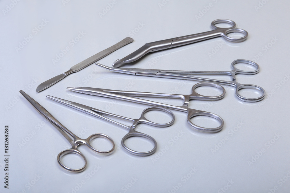surgical instruments and tools including scalpels, forceps tweezers arranged on a table for surgery surgical instruments and tools including scalpels, forceps tweezers arranged on a table for surgery