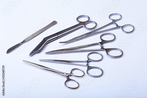 surgical instruments and tools including scalpels, forceps tweezers arranged on a table for surgery