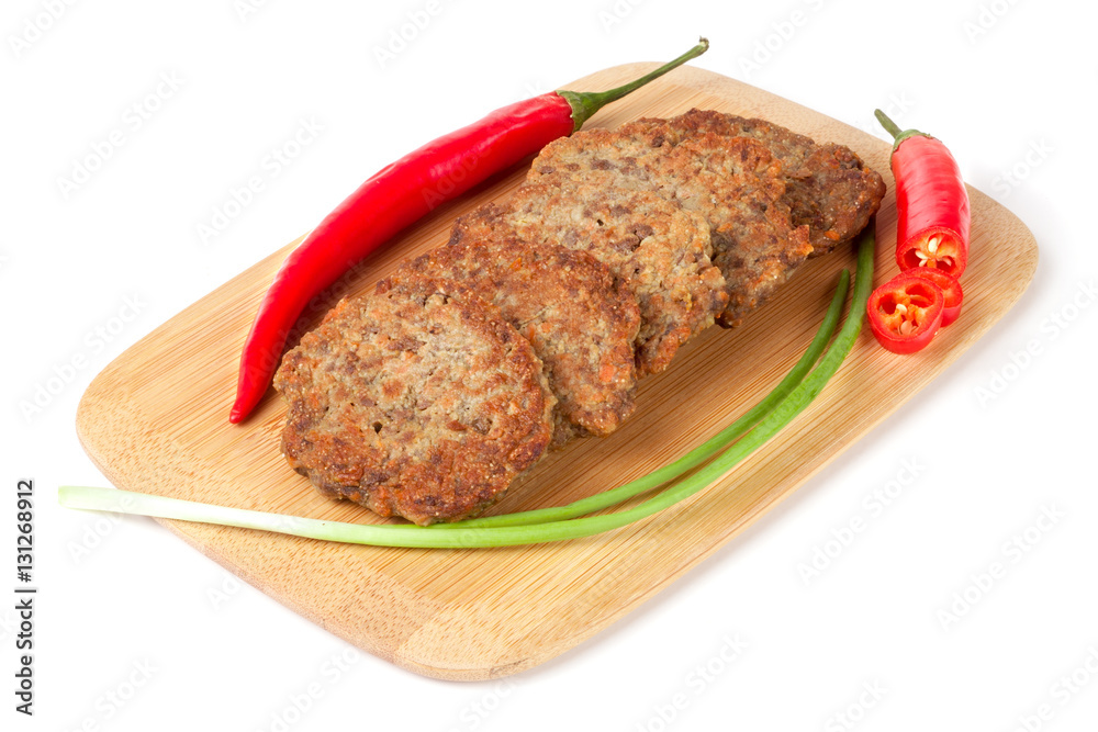 liver pancakes or cutlets with chilli and spring onions on a cutting board isolated white background liver pancakes or cutlets with chilli and spring onions on a cutting board isolated white background