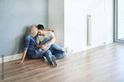 Couple sitting on the floor in their new apartment.