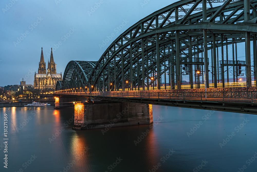 Fototapeta premium Bridge over the Rhine river in Cologne at the early morning blue hours sun light