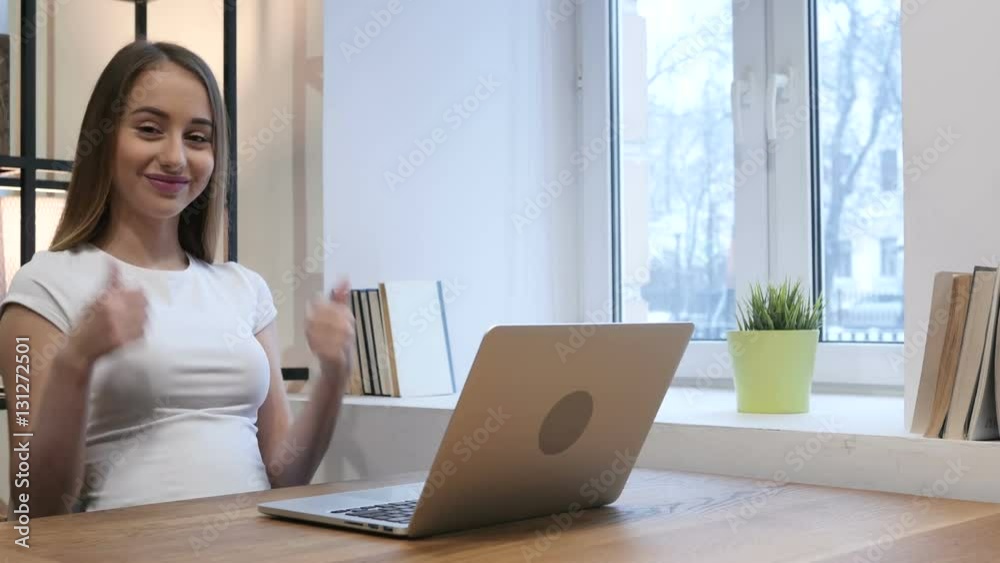 Thumbs Up by Young Girl while Working on Laptop