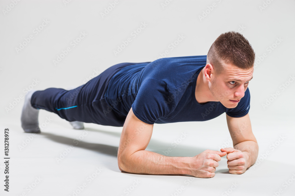 Studio shot image of young man who is stretching his body. 